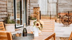 a table with a bottle of wine and flowers on it at The Piggery in Yarpole +15 photos