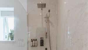 a shower in a white bathroom with a shower at The Piggery in Yarpole