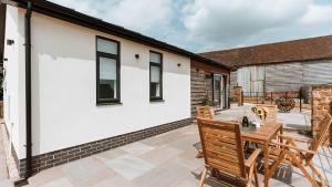 a patio with a table and chairs on a house at The Piggery in Yarpole