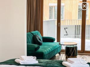 sala de estar con sofá verde y silla en Apartmán Esprit Y31, en Dolný Kubín