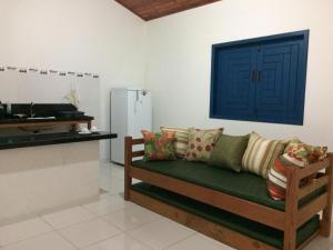 a living room with a couch and a blue door at Recanto das Geraes in Arraial d'Ajuda