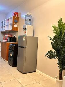 a refrigerator in a room with a plant at Residence Next Door Coral Mega in Kiambu