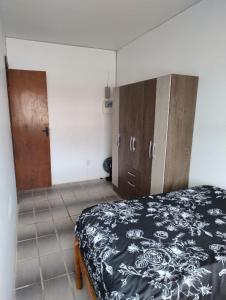 a bedroom with a bed and wooden cabinets at Apartamento Duplex na praia de Salinas RS in Cidreira