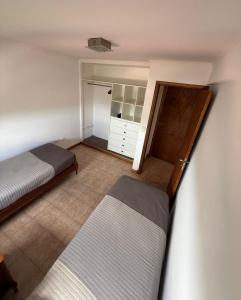 een slaapkamer met 2 bedden en een kast bij Estrada Depto con Vista al Mar, 4 Ambientes in Mar del Plata