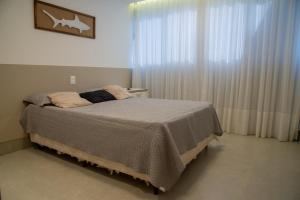 a bedroom with a bed and a window with curtains at Guarapari Bacutia Peracanga an1 in Guarapari