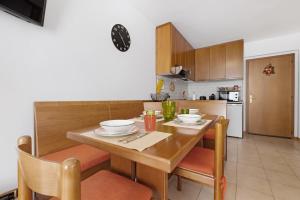 a kitchen and dining room with a wooden table and chairs at La finestra sui monti - Breguzzo in Breguzzo