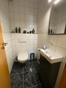 a bathroom with a white toilet and a sink at Ferienwohnung Alexa an der Dhron in Neumagen-Dhron