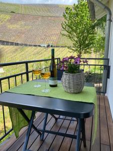 a table with two glasses of wine on a balcony at Ferienwohnung Alexa an der Dhron in Neumagen-Dhron +1 photo