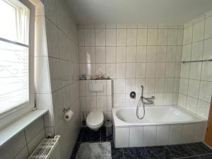 a bathroom with a toilet and a tub and a sink at Ferienwohnung Alexa an der Dhron in Neumagen-Dhron