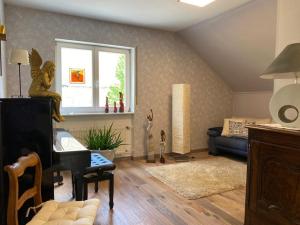 a living room with a piano and a couch at Ferienwohnung Alexa an der Dhron in Neumagen-Dhron
