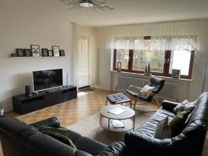 a living room with a couch and a table at Schwarzwald Style DreiWelten Card inkl freier Eintritt Solemar Ruhige Fewo mit 85 qm zentral Parkanlage Stellplatz in Bad Dürrheim