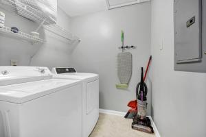 a white bathroom with a sink and a washing machine at Sawgrass Cottage 3BR w Deck in Columbia +20 photos