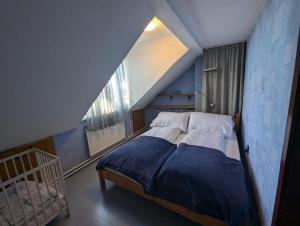 a bedroom with a bed with a blue wall at Family Apartman by Budapest in Göd