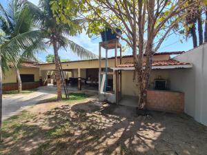 a building with two palm trees in front of it at Hospedagem e queijaria Péua in Soure +13 photos