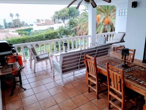 a dining room with a table and chairs on a balcony at Villa Tranquilla in Estepona