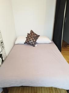 a bed with white sheets and a pillow on it at Gite piscine privée climatisation in Célon +12 photos