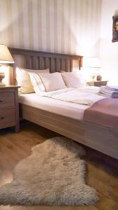 1 cama con cabecero de madera y alfombra en Brașov Residential, en Brasov