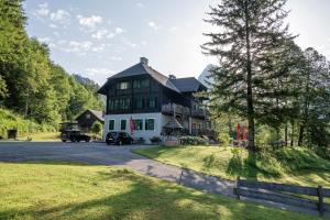 una grande casa con una macchina parcheggiata di fronte di Nationalpark Gesäuse Lodge a Gstatterboden