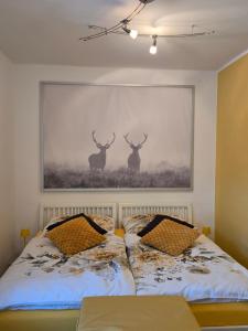 una camera da letto con un dipinto di due cervi sul muro di Alpenblumal a Bad Goisern
