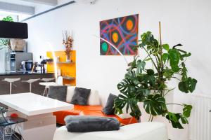 Una sala de estar con un sofá y una planta. en Modern Central Leiden Family Apt - Sleeps 6 and Baby, en Leiden