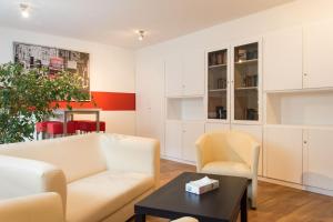 a living room with a couch and chairs and a table at 1, 2, sleep Hostel Nürnberg Messe in Nuremberg