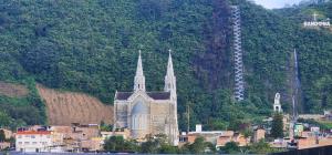 a church with two spires in front of a mountain at Molina House Sandona in Sandoná