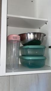 a shelf with bowls and a bowl on it at Casa Aeroporto Premium Conforto e Conveniência para Sua Estadia in Campo Grande