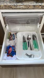 a white container with utensils in a drawer at Casa Aeroporto Premium Conforto e Conveniência para Sua Estadia in Campo Grande