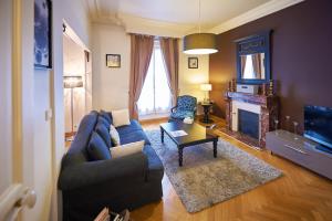 a living room with a blue couch and a fireplace at Appartements Plantagenet - Le 33 in Le Mans