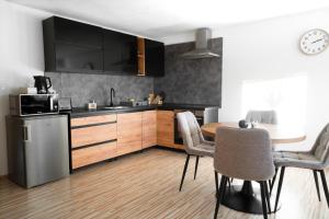 a kitchen with wooden cabinets and a table with chairs at Apartmány Filip&Luky in Lendak