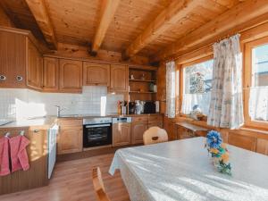kuchnia z drewnianymi szafkami i stołem w pokoju w obiekcie Apartment Geislhof by Interhome w mieście Bramberg am Wildkogel