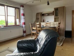 a living room with a leather couch and a table at LeaID in Idstedt