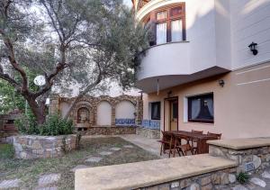 a house with a table and chairs in a yard at Aslanis-Souroti Garden FAMILY Suite in Sourotí