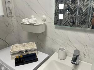 um banheiro branco com uma pia e um espelho em Silesia Blue2 Apartment - Katowice em Katowice mais 22 fotografias