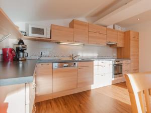 kuchnia z drewnianymi szafkami i urządzeniami ze stali nierdzewnej w obiekcie Apartment Tauernblick by Interhome w mieście Bramberg am Wildkogel +31 zdjęć