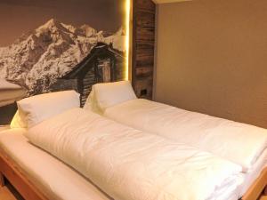 Apartment Wiedersehn Dachgeschoss by Interhome في غريشين: سريرين في غرفة مع صورة للجبل