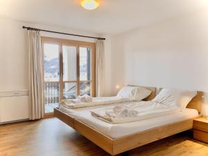 a bedroom with two beds and a large window at Apartment Residenza Chesa Margun 79-3 by Interhome in Surlej