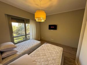 a room with two beds and a window at The Pyramid Escape in Cairo