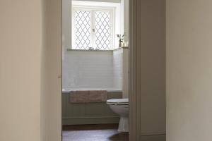 ein Badezimmer mit Toilette und Fenster in der Unterkunft Fern Cottage Coach House in Batheaston + 27 Fotos