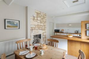 eine Küche mit einem Holztisch und einem Kamin in der Unterkunft Fern Cottage Coach House in Batheaston