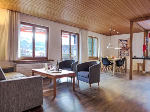 Una sala de estar con un sofá y sillas y una mesa. en Apartment Chalet Bienli Mitte by Interhome, en Grindelwald