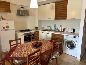 a kitchen with a table and a kitchen with a washing machine at Casa Maria a Camigliatello silano in Camigliatello Silano
