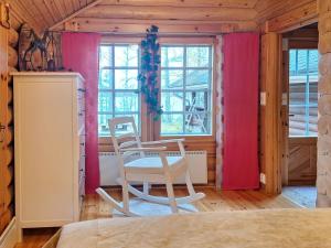 een slaapkamer met roze gordijnen en een tafel en stoelen bij Holiday Home Honkaranta by Interhome in Karstula