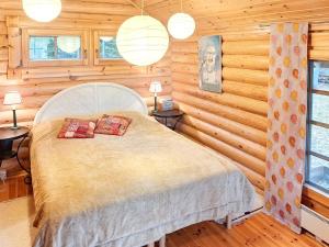 een slaapkamer met een bed in een blokhut bij Holiday Home Honkaranta by Interhome in Karstula