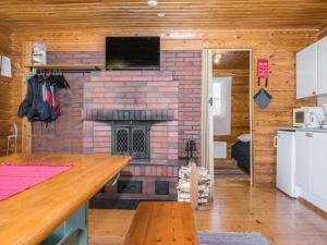 a kitchen with a brick fireplace in a log cabin at Holiday Home Eteläranta by Interhome in Hara