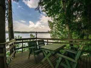 - une terrasse en bois avec une table de pique-nique et 2 chaises dans l'établissement Holiday Home Iltarusko by Interhome, à Hara