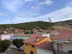 a group of buildings with a hill in the background at Your village house in Hoyo de Pinares