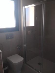 une salle de bain avec toilettes et douche en verre dans l'établissement Moderno apartamento con piscina R35 by Novadesta, à Arenales del Sol 3 autres photos