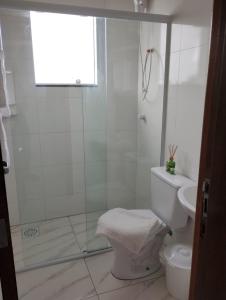 une salle de bain blanche avec douche et toilettes dans l'établissement Apartamento Praia do Sonho- CasaMora, à Palhoça