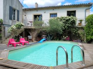 a swimming pool in front of a house at Maison Vigneronne in Salinelles